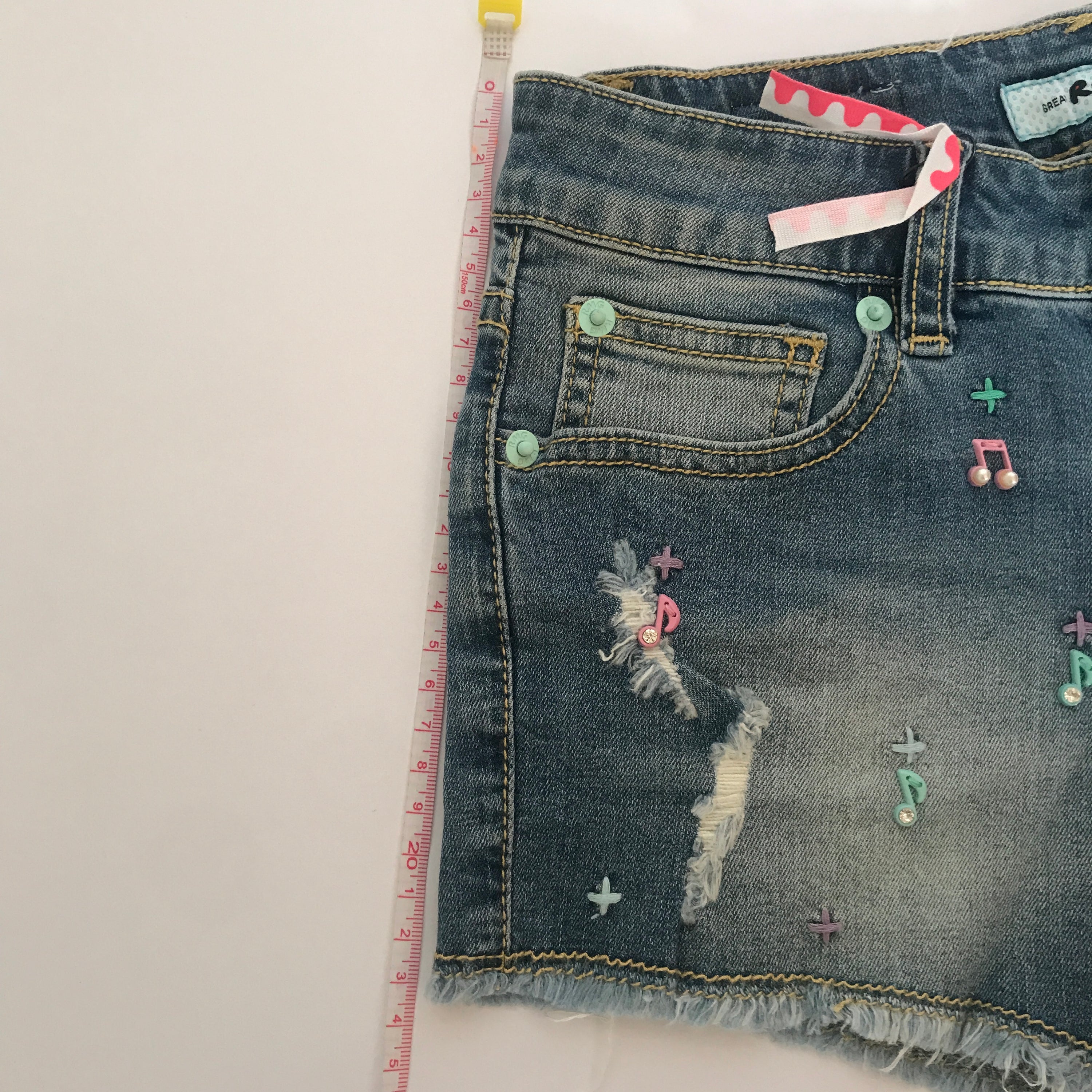 A pair of stylish denim shorts featuring a unique music notes design, made from a comfortable cotton and spandex blend.