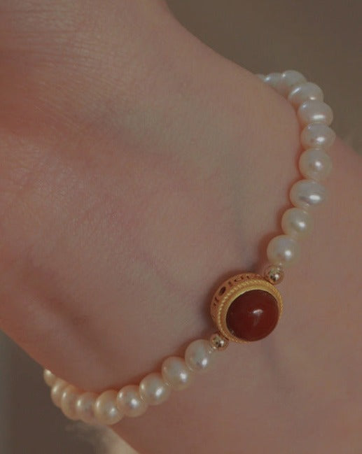 Natural Freshwater Pearl Bracelet featuring a vibrant red gemstone accent, showcasing elegant pearls and a striking design.