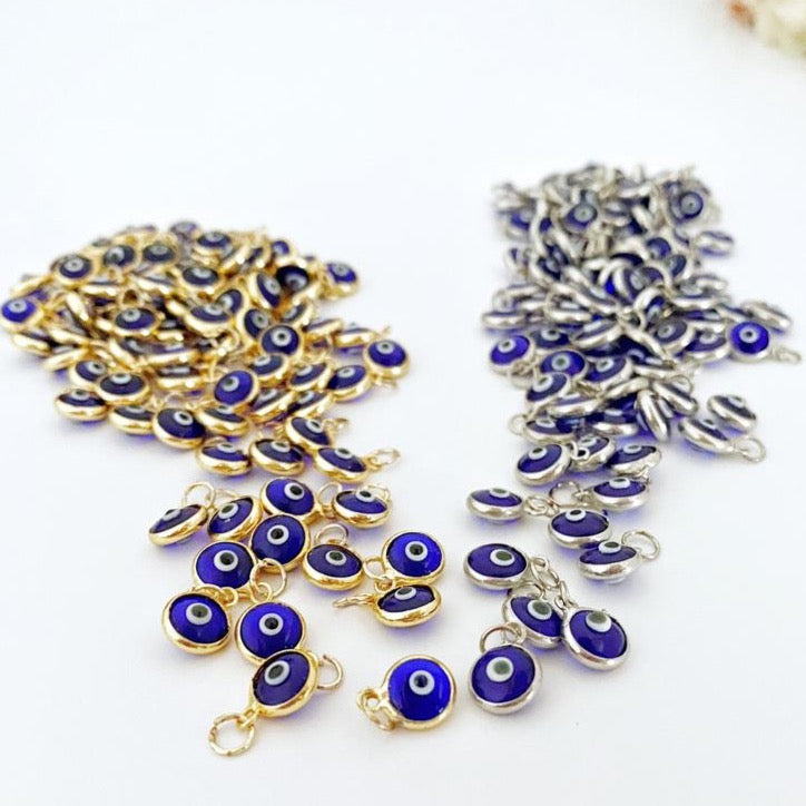 A pack of five 6mm navy blue evil eye charms, featuring gold and silver accents, perfect for DIY jewelry making.