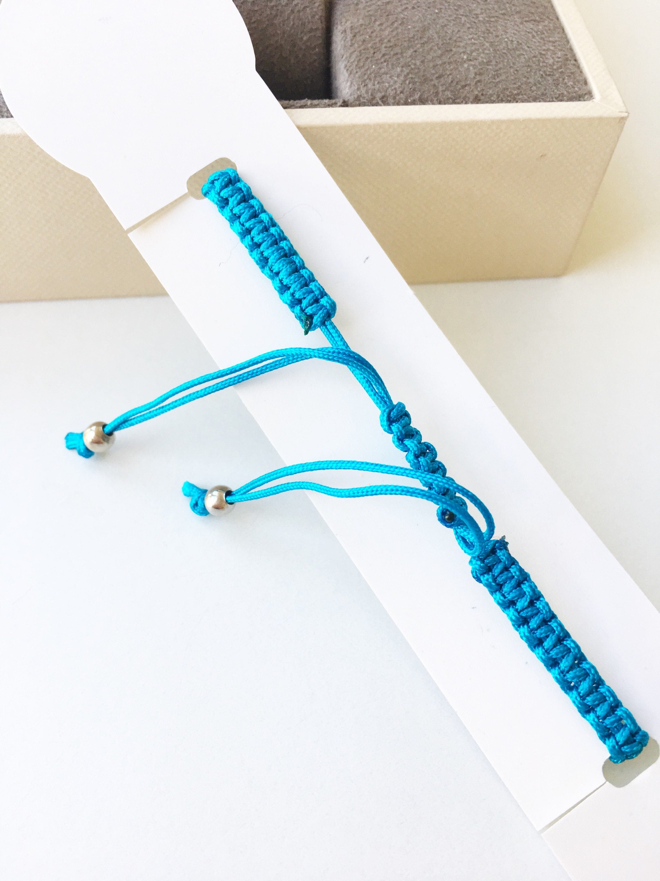 Handmade Nazar Boncuk Bracelet featuring an adjustable macrame design with an evil eye charm in black and white options.