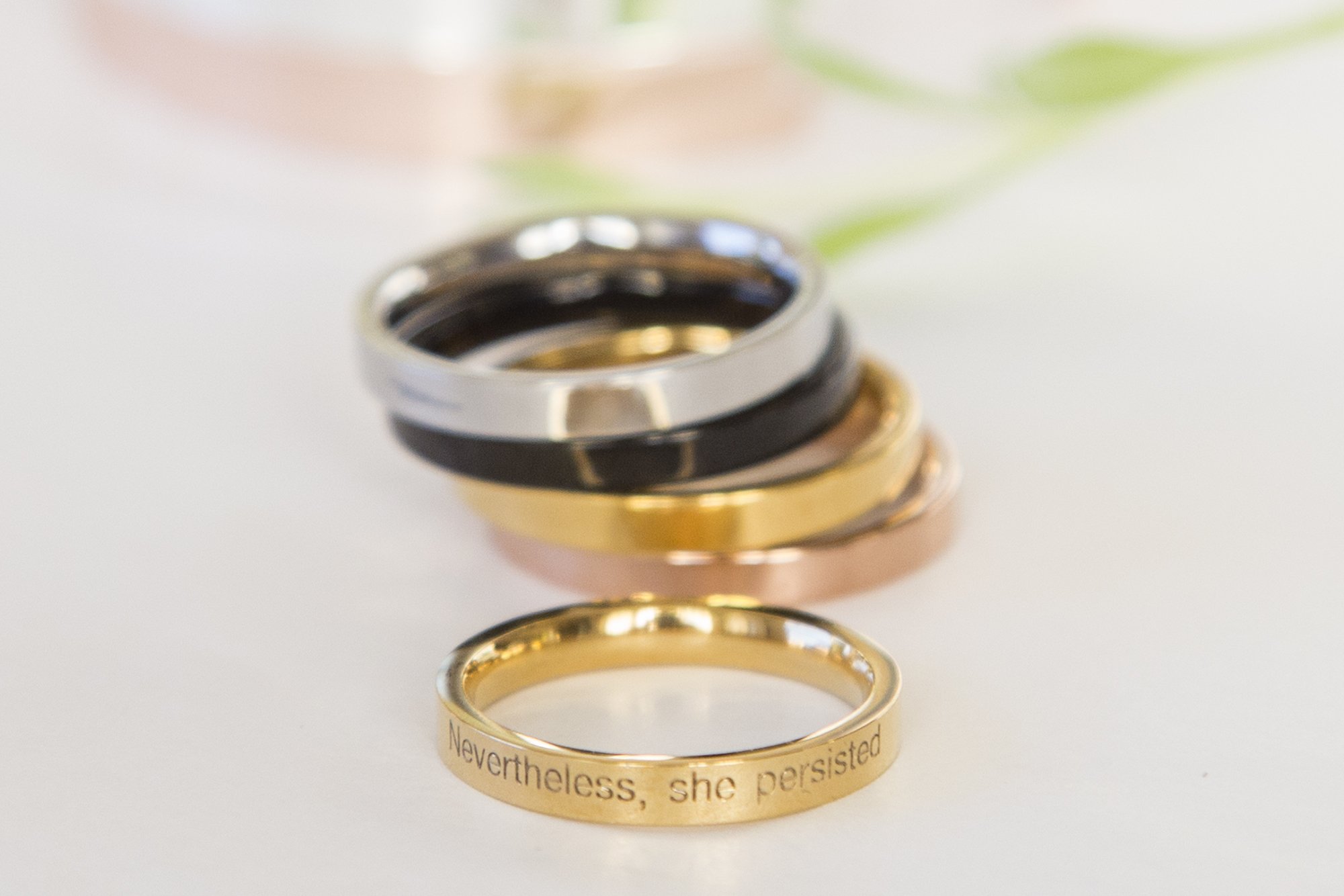 Nevertheless She Persisted Ring in gold, rose gold, and black plating, showcasing its elegant design and empowering engraved message.