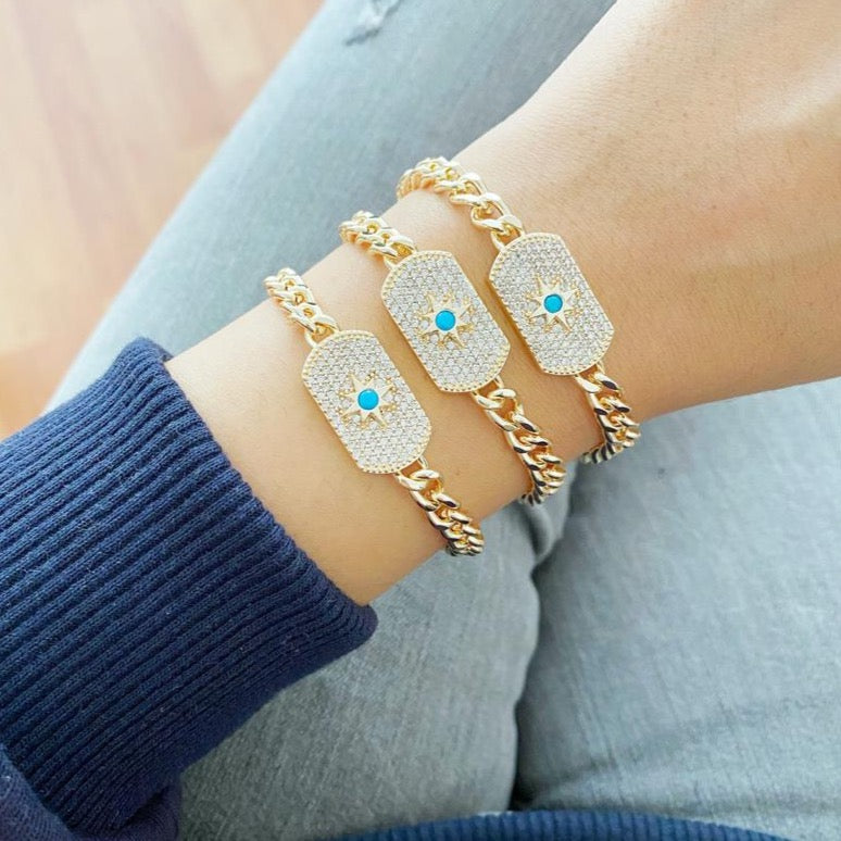 North Star Charm Bracelet featuring a gold curb chain and zircon charms, adjustable for all wrist sizes.