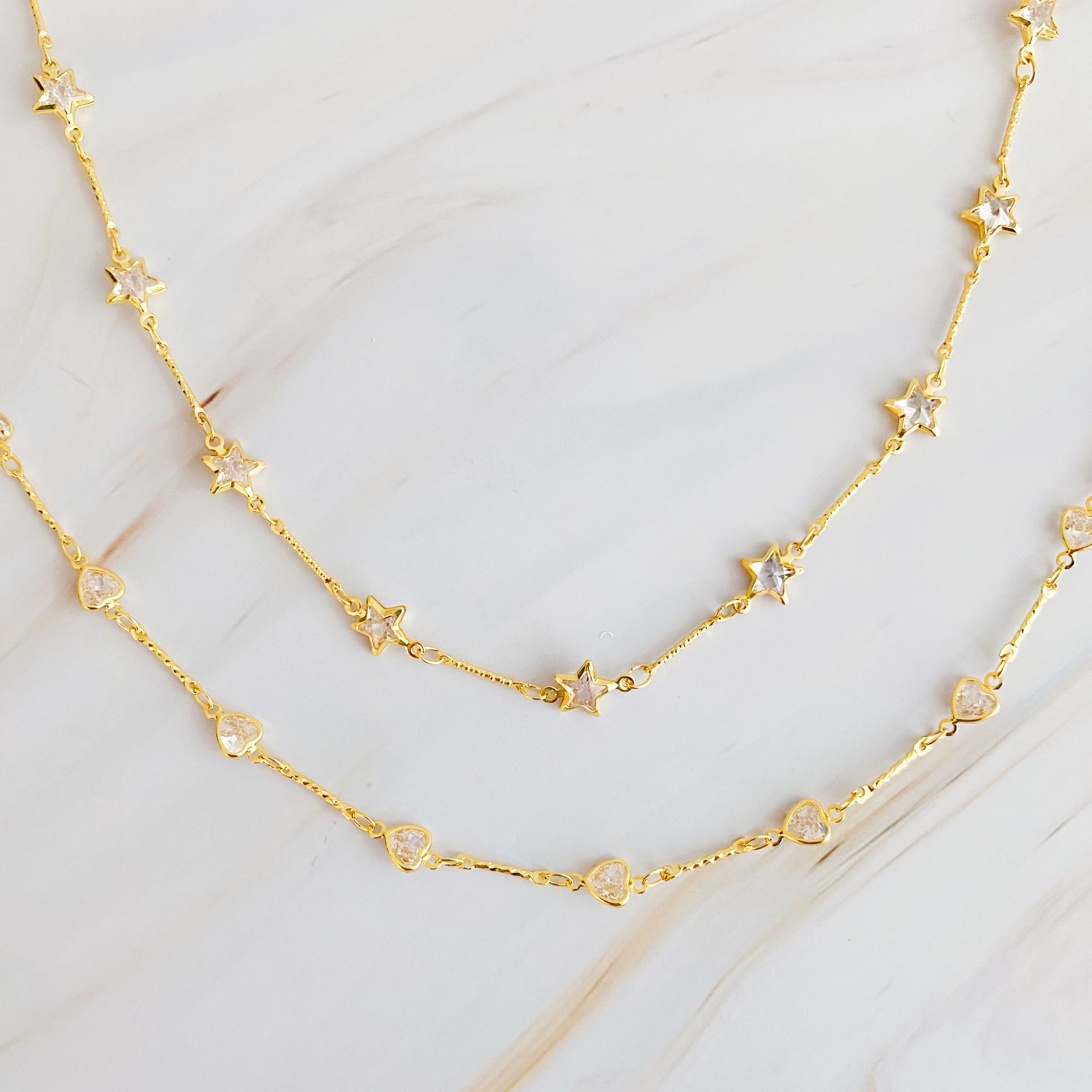 Oh My Shaped Sparkling Necklace featuring a star or heart design with cubic zirconia on a gold plated chain.