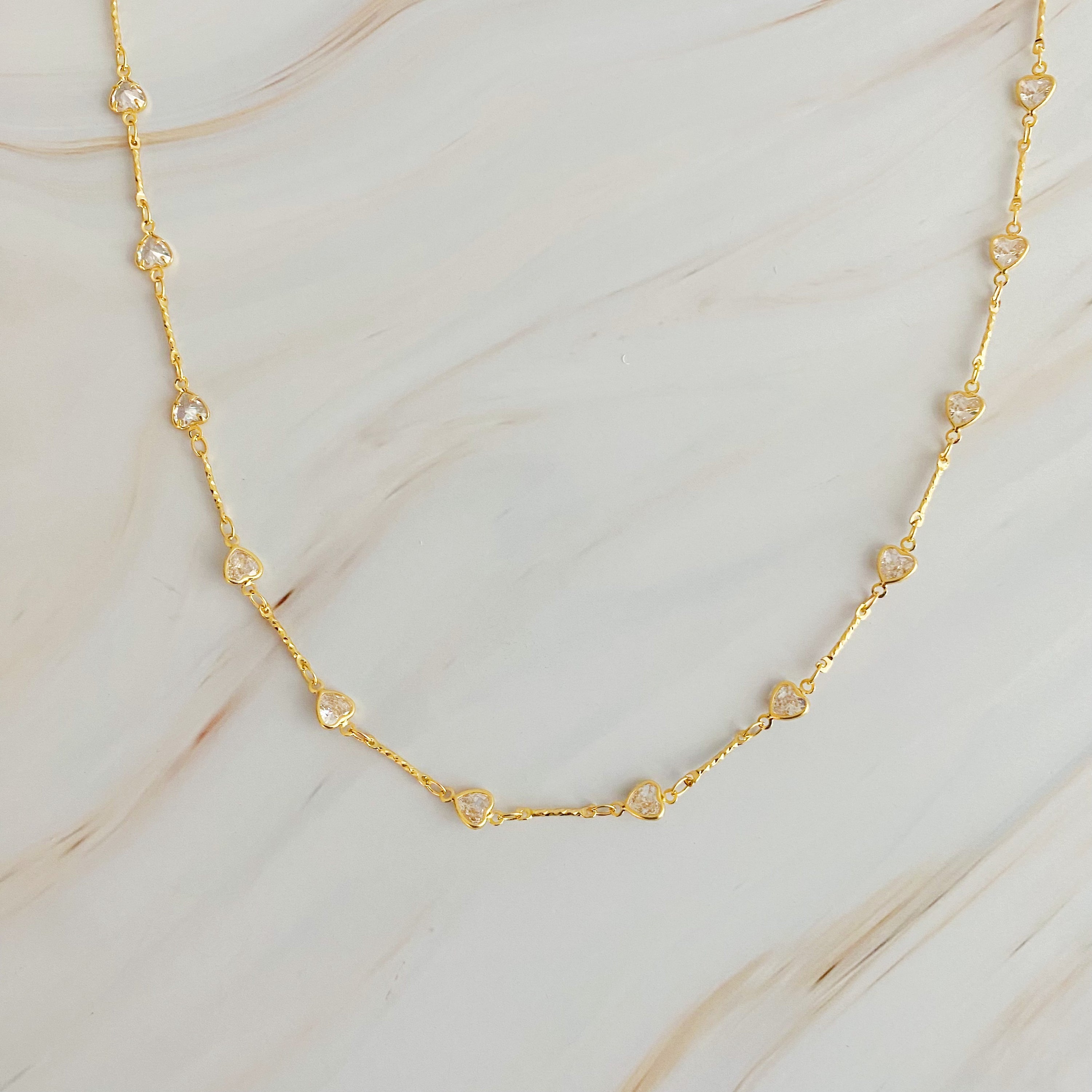 Oh My Shaped Sparkling Necklace featuring a star or heart design with cubic zirconia on a gold plated chain.