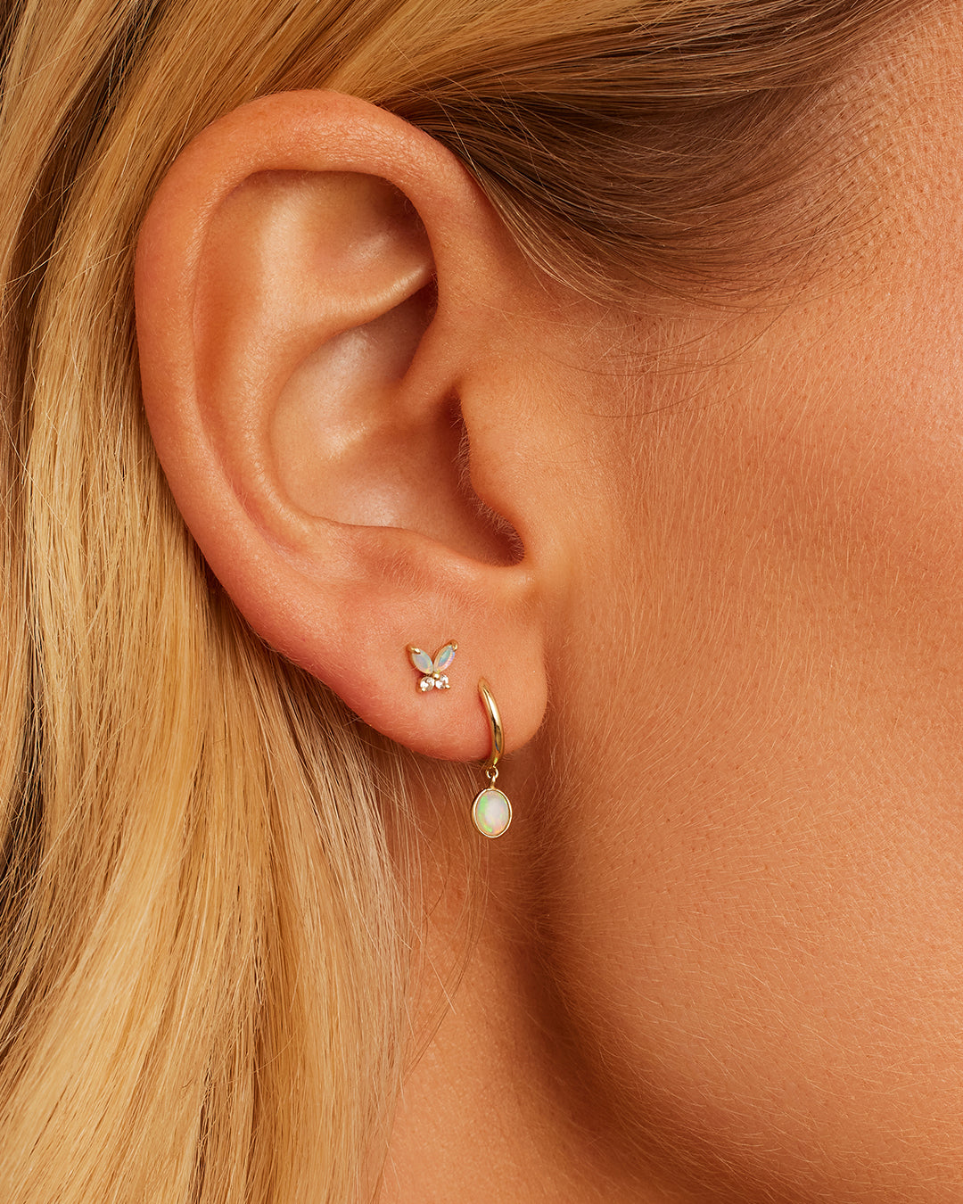 Elegant Opal Oval Charm Huggies earrings featuring a secure huggie design and colorful opal charm.