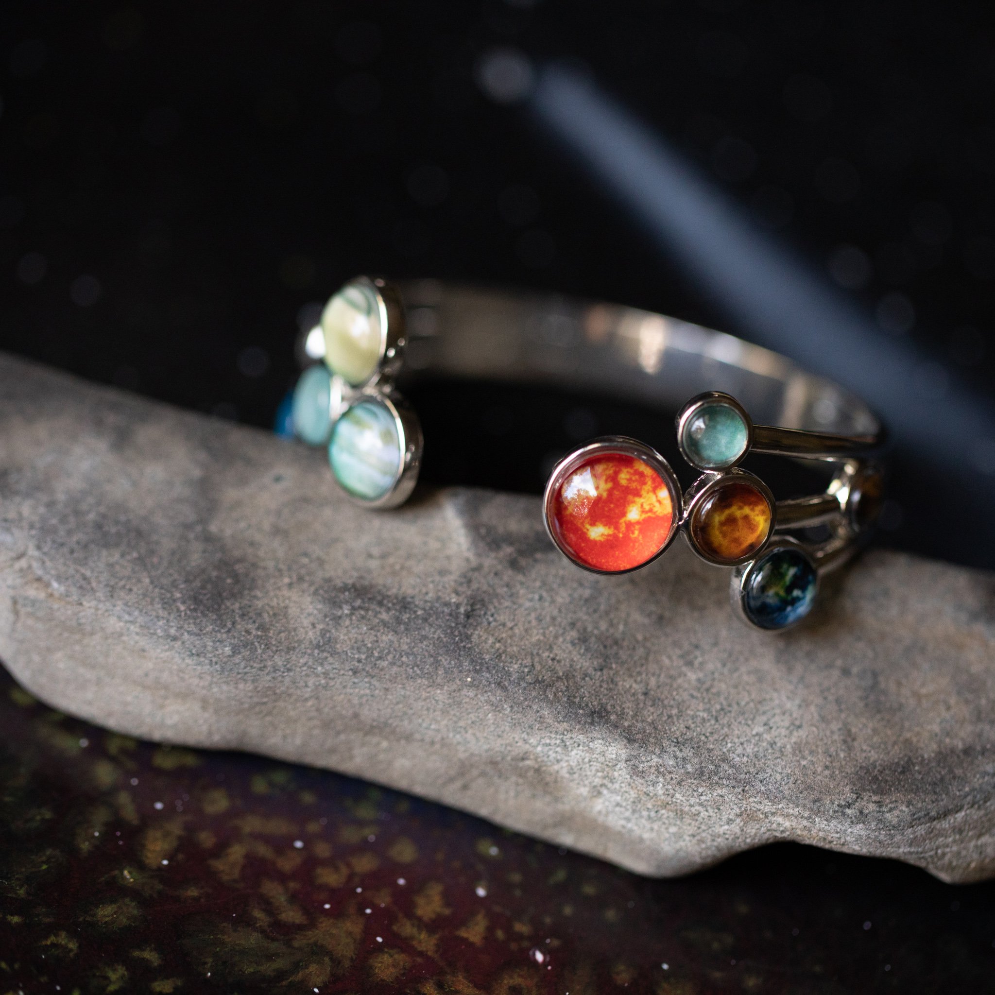 Open Solar System Cuff Bracelet featuring 9 planets and the Sun, adjustable silver-tone design, handcrafted from rhodium plated brass.