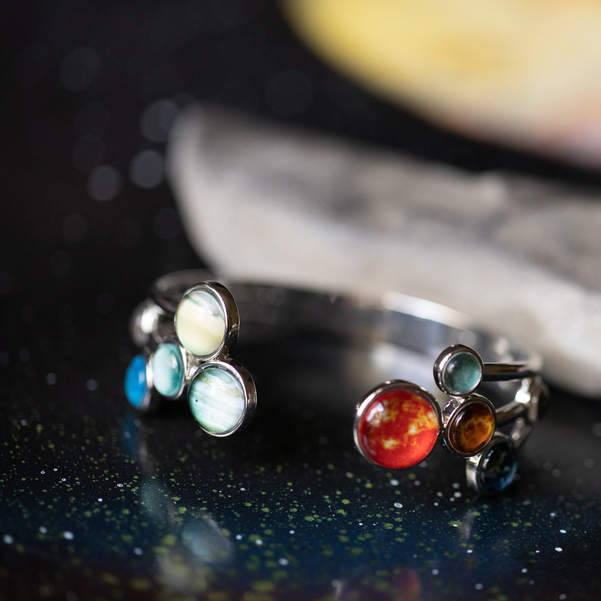 Open Solar System Cuff Bracelet featuring 9 planets and the Sun, adjustable silver-tone design, handcrafted from rhodium plated brass.