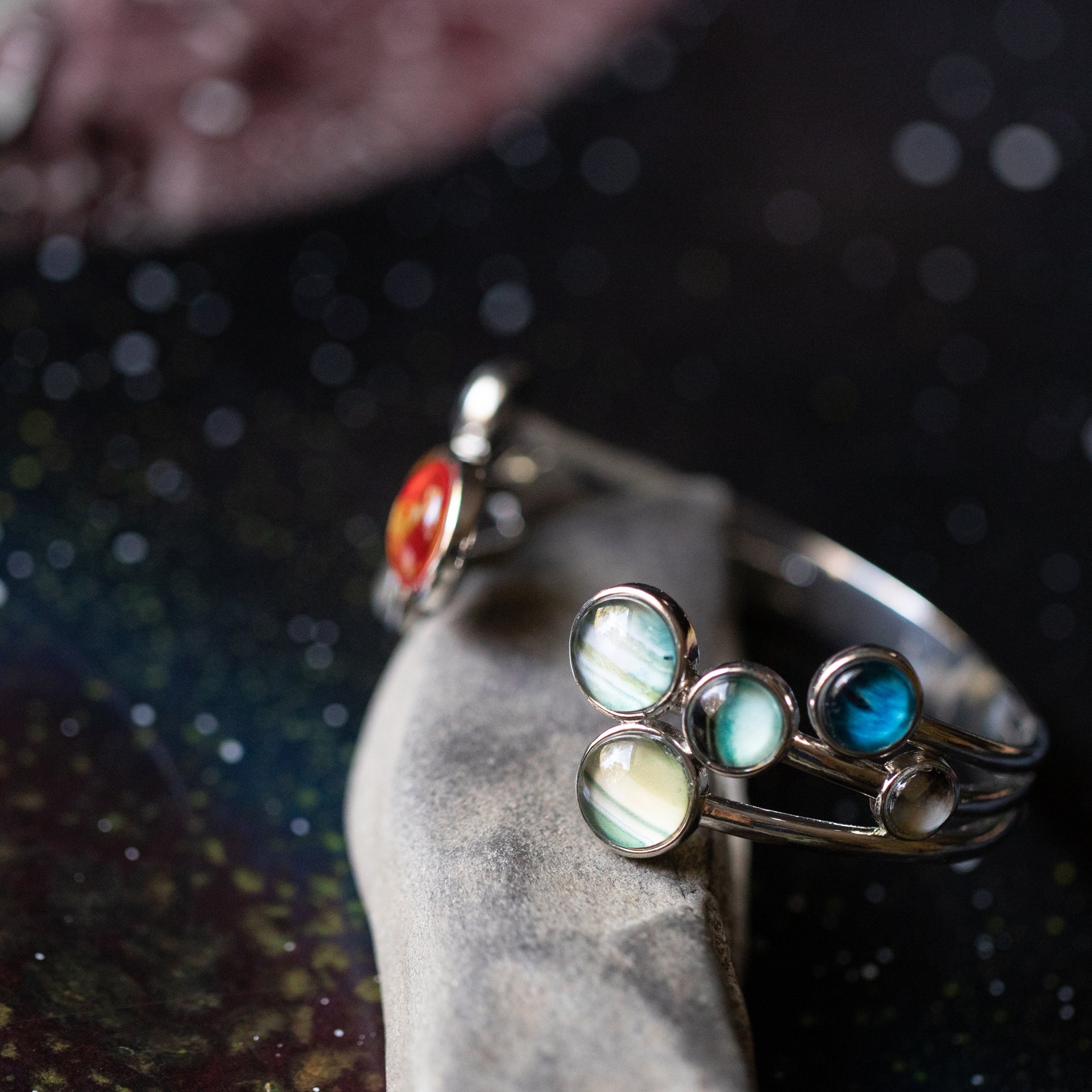 Open Solar System Cuff Bracelet featuring 9 planets and the Sun, adjustable silver-tone design, handcrafted from rhodium plated brass.