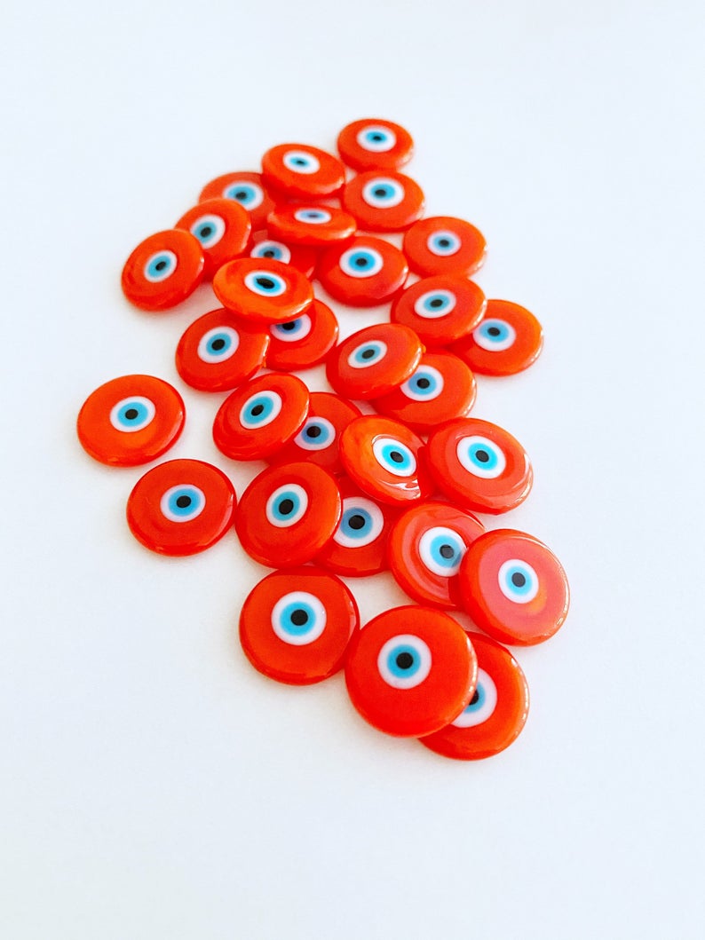 A collection of vibrant orange 15mm Murano glass cabochons featuring the evil eye design, perfect for jewelry making.