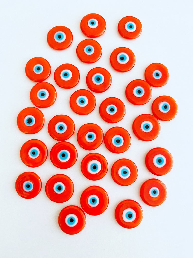 A collection of vibrant orange 15mm Murano glass cabochons featuring the evil eye design, perfect for jewelry making.