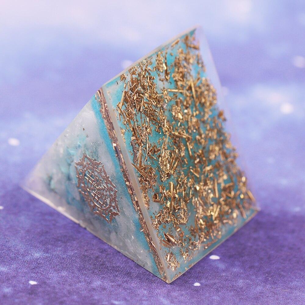 A handcrafted Orgone Crystal Gemstone Pyramid made of turquoise, white crystal, and copper scraps, designed for energy generation and home decor.