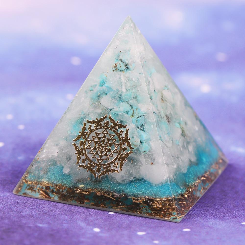 A handcrafted Orgone Crystal Gemstone Pyramid made of turquoise, white crystal, and copper scraps, designed for energy generation and home decor.