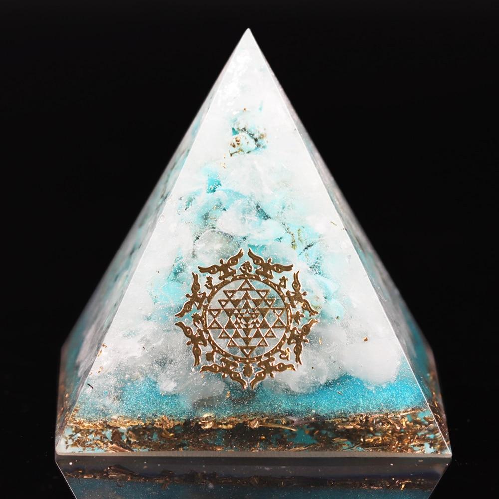 A handcrafted Orgone Crystal Gemstone Pyramid made of turquoise, white crystal, and copper scraps, designed for energy generation and home decor.