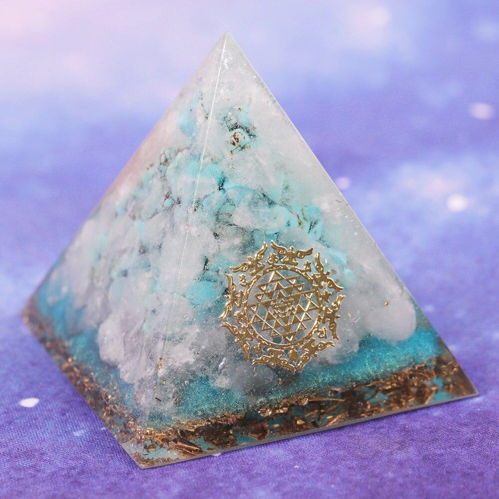 A handcrafted Orgone Crystal Gemstone Pyramid made of turquoise, white crystal, and copper scraps, designed for energy generation and home decor.