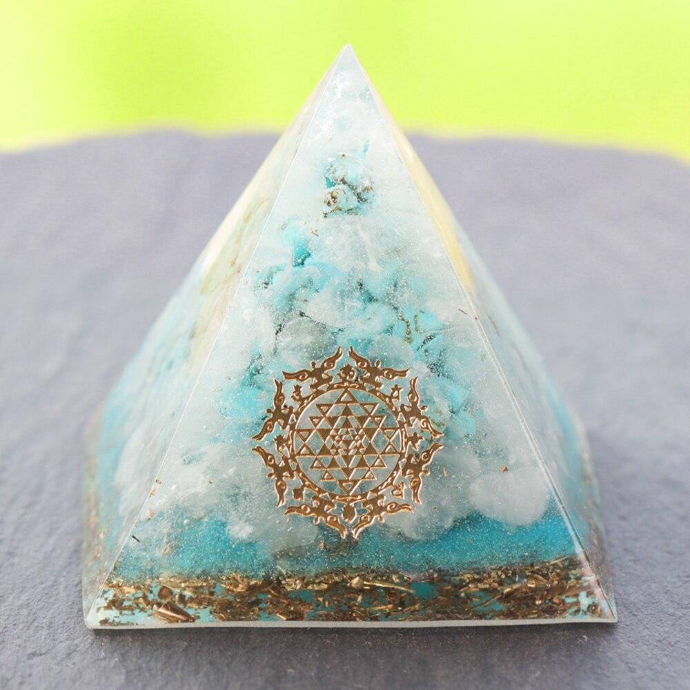 A handcrafted Orgone Crystal Gemstone Pyramid made of turquoise, white crystal, and copper scraps, designed for energy generation and home decor.