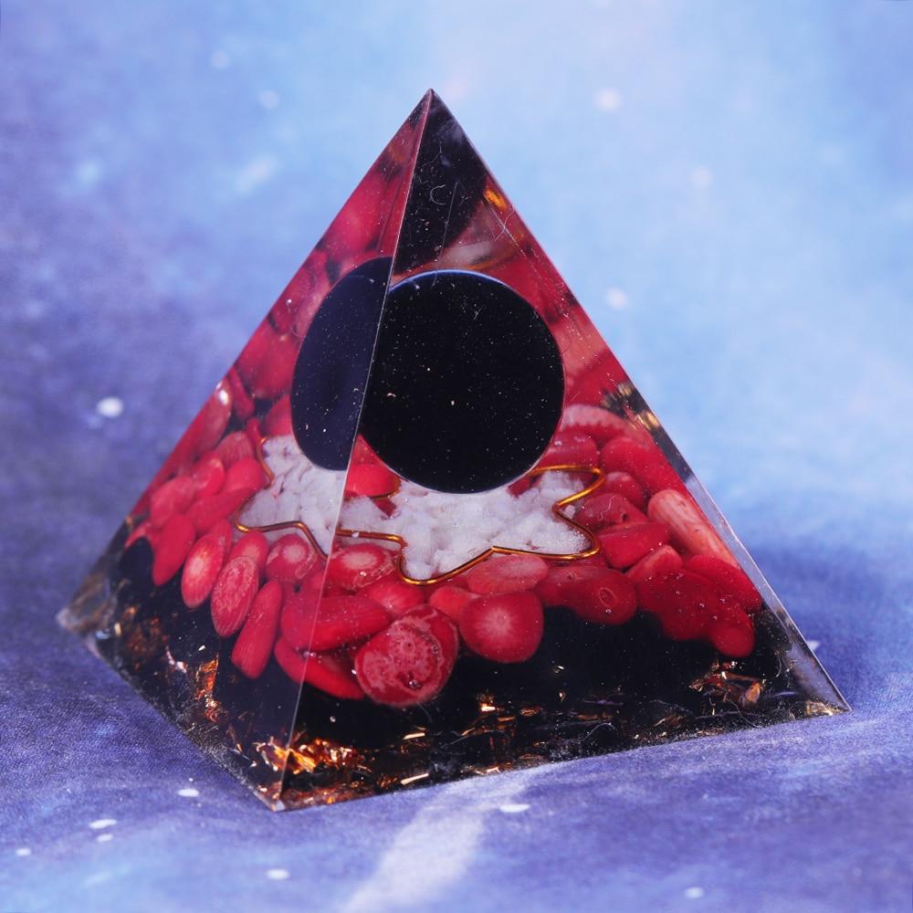 A handcrafted Orgonite pyramid made of natural obsidian, red coral, copper, and gold foil, designed for energy healing and meditation.