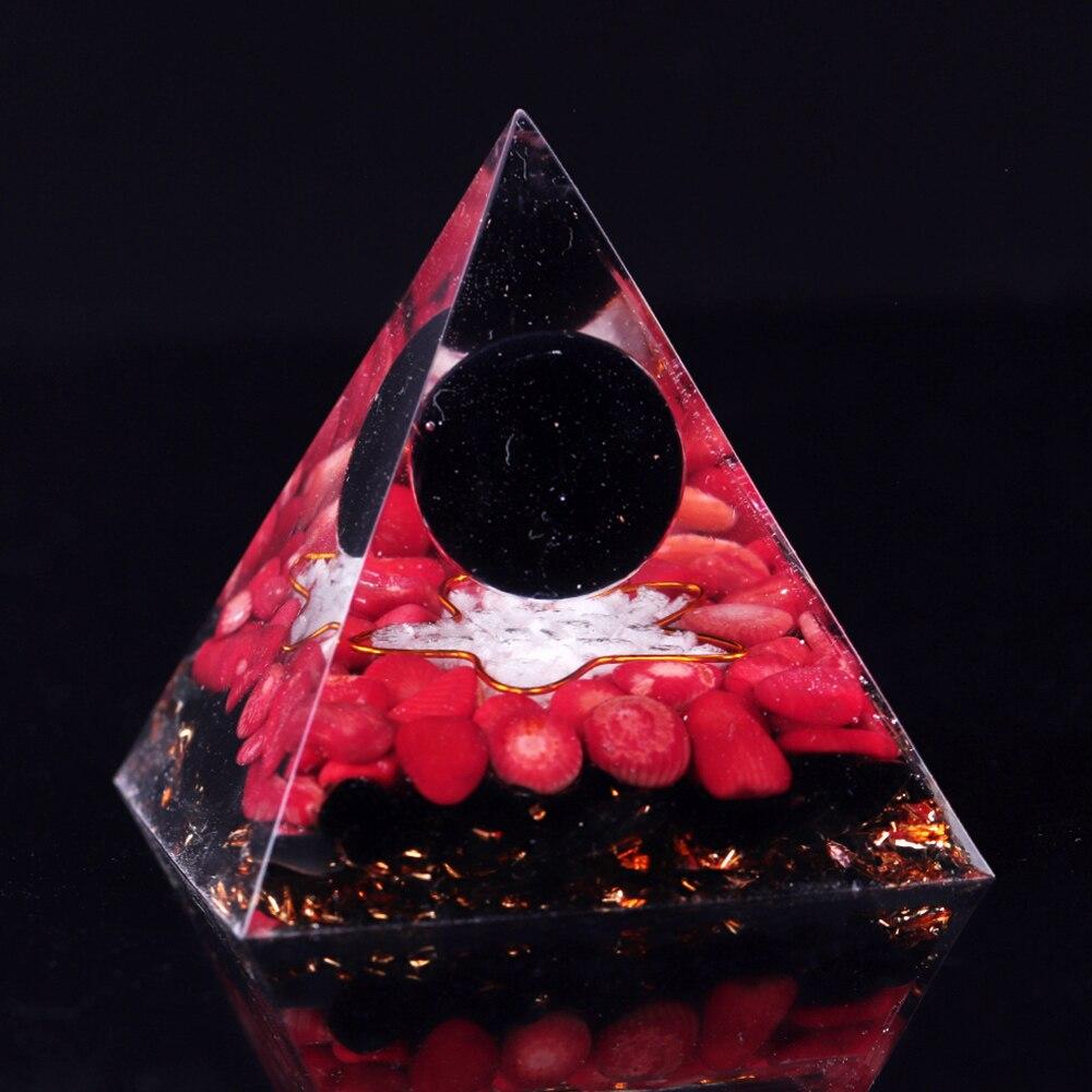 A handcrafted Orgonite pyramid made of natural obsidian, red coral, copper, and gold foil, designed for energy healing and meditation.