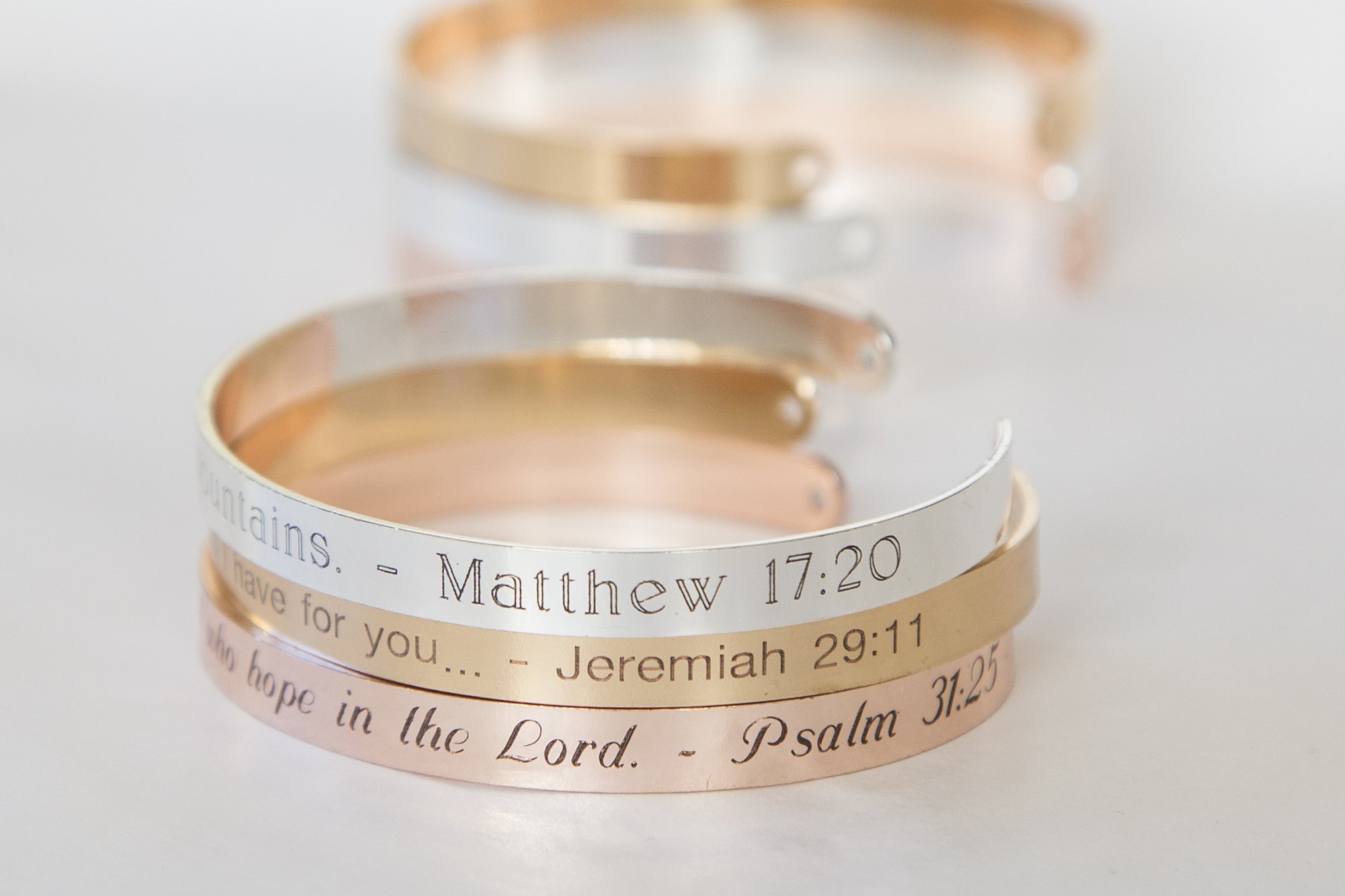 A delicate adjustable bracelet featuring the quote 'Our faith can move mountains' engraved, available in gold, rose gold, and silver finishes.