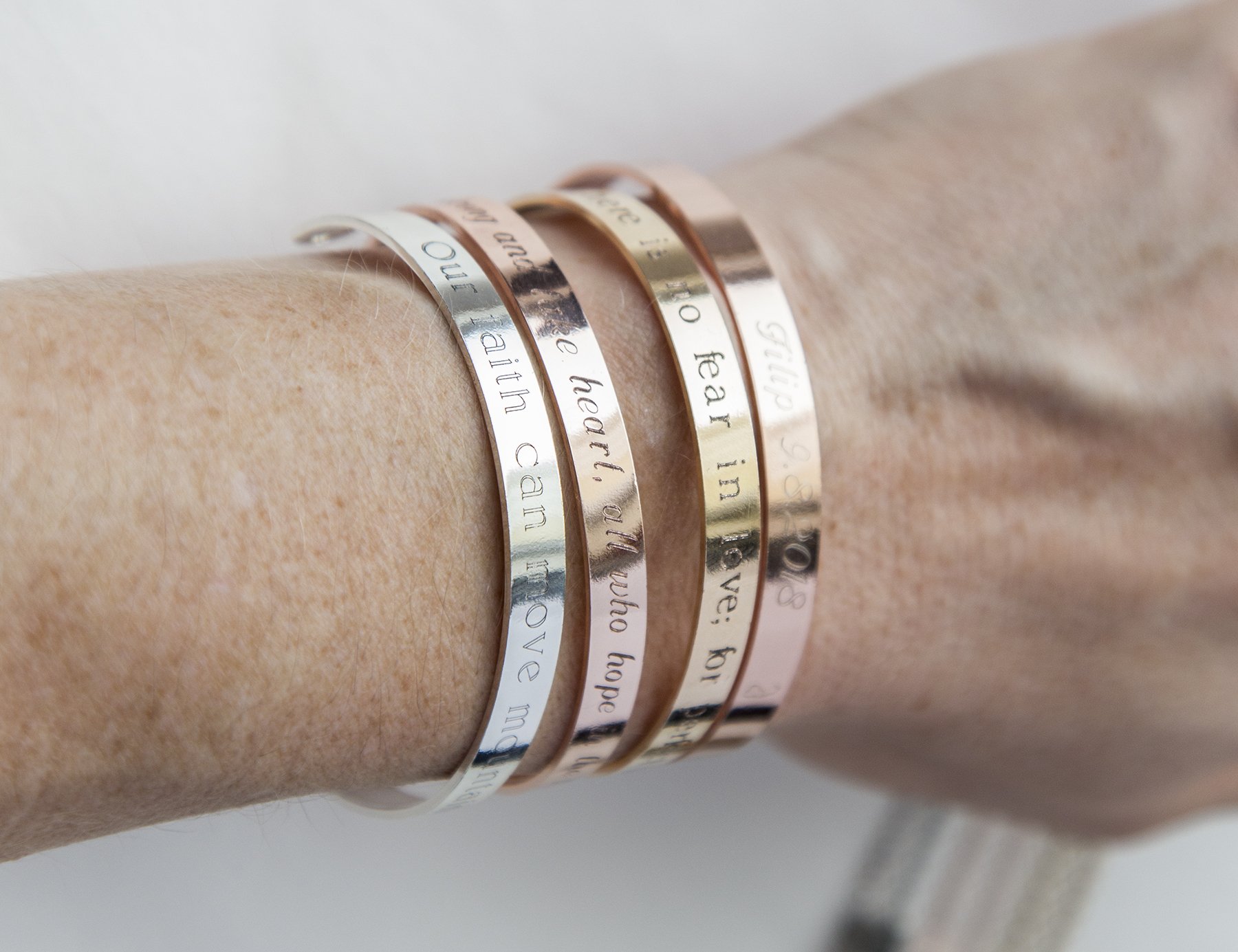 A delicate adjustable bracelet featuring the quote 'Our faith can move mountains' engraved, available in gold, rose gold, and silver finishes.