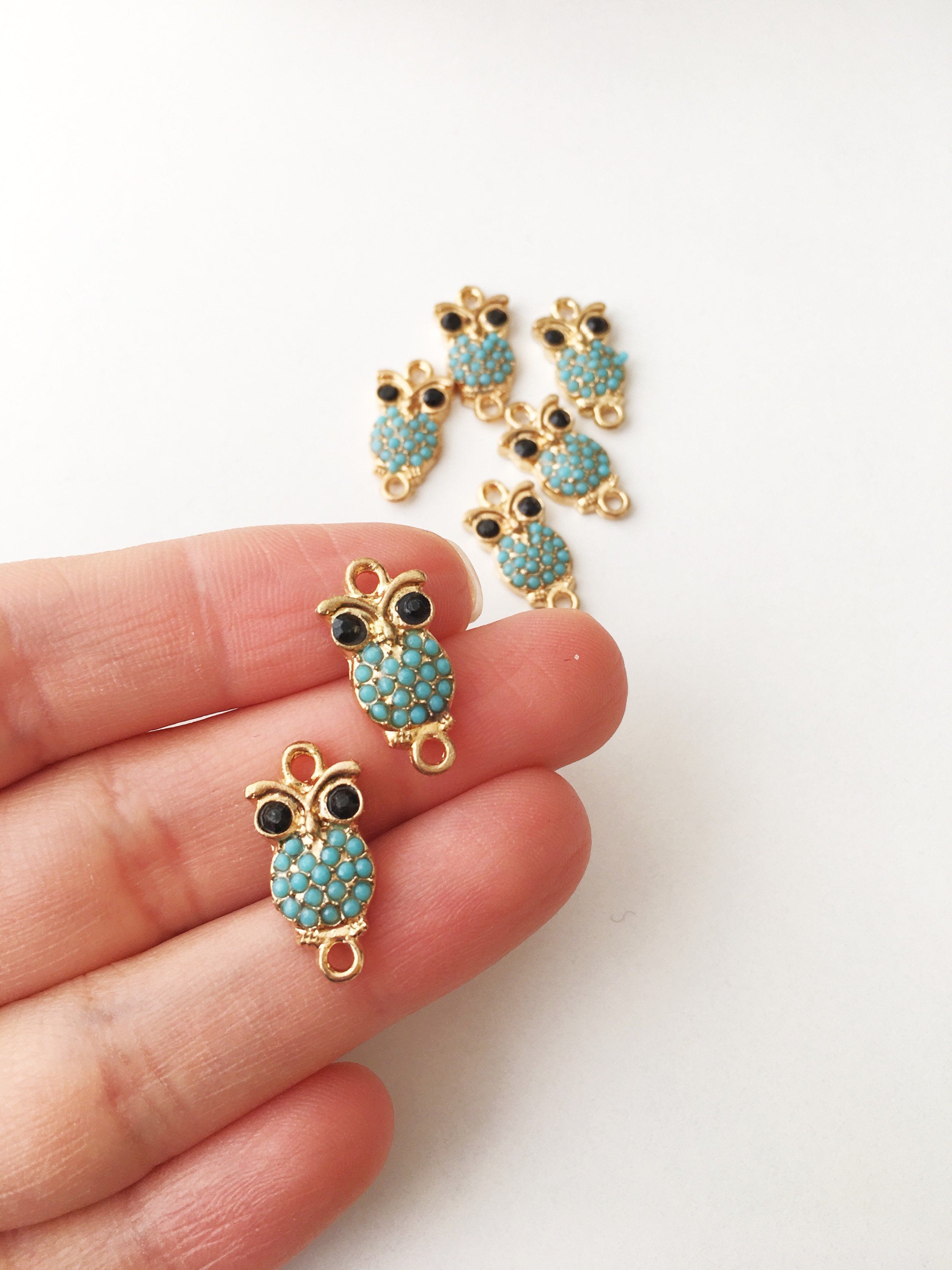 Two turquoise owl evil eye charms, perfect for jewelry making and DIY projects, showcasing intricate details and vibrant color.
