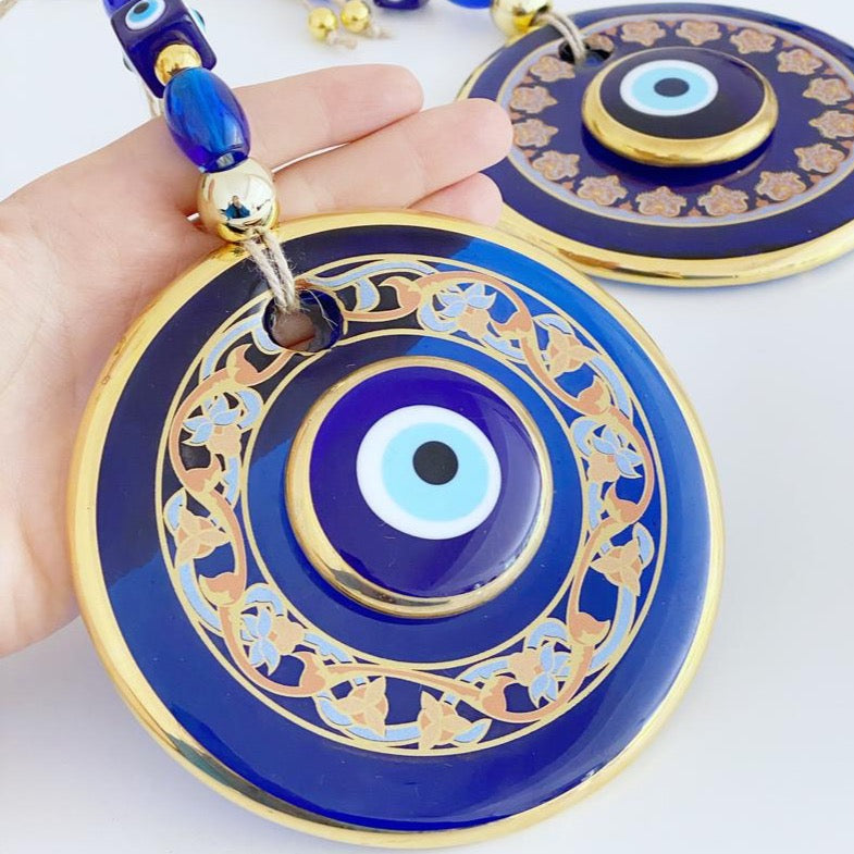 Handmade patterned evil eye wall hanging featuring blue and gold beads, measuring 32cm in length, showcasing intricate mosaic art.