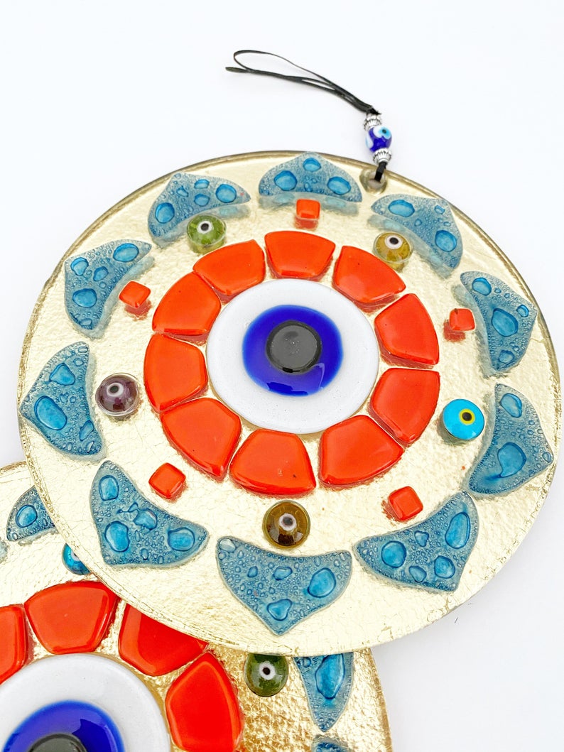 Handmade orange patterned evil eye wall hanging made of glass, featuring unique designs and vibrant colors, perfect for home decor.