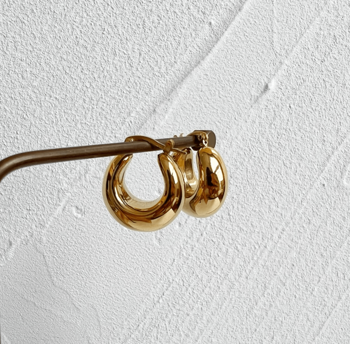 Pattie Chunky Polished Gold Creole Earrings showcasing a unique polished design, lightweight structure, and elegant gold finish.