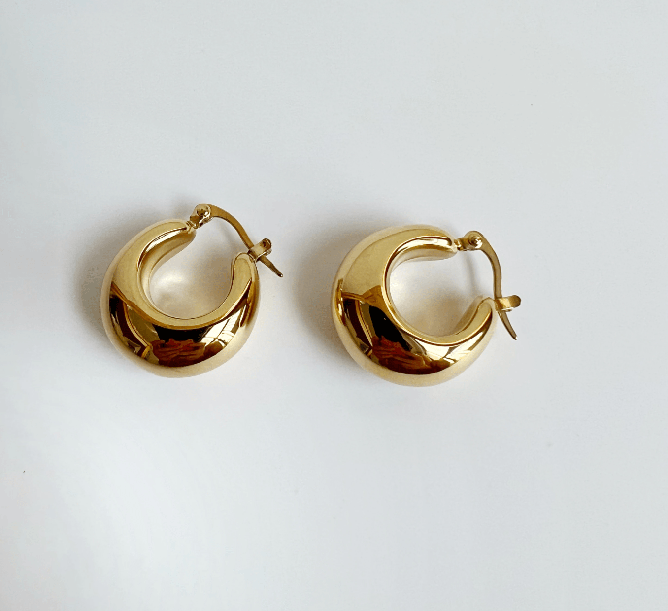 Pattie Chunky Polished Gold Creole Earrings showcasing a unique polished design, lightweight structure, and elegant gold finish.
