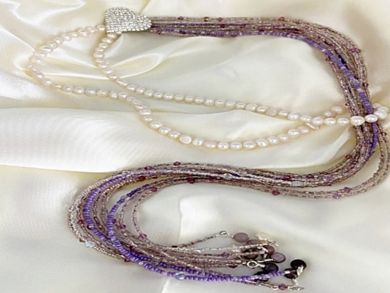 A beautiful Pearl and Lilac Jade Lariat Necklace featuring freshwater pearls, lilac jade, and a faux rhinestone heart button, elegantly displayed.