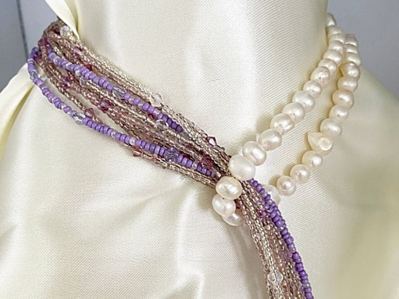 A beautiful Pearl and Lilac Jade Lariat Necklace featuring freshwater pearls, lilac jade, and a faux rhinestone heart button, elegantly displayed.