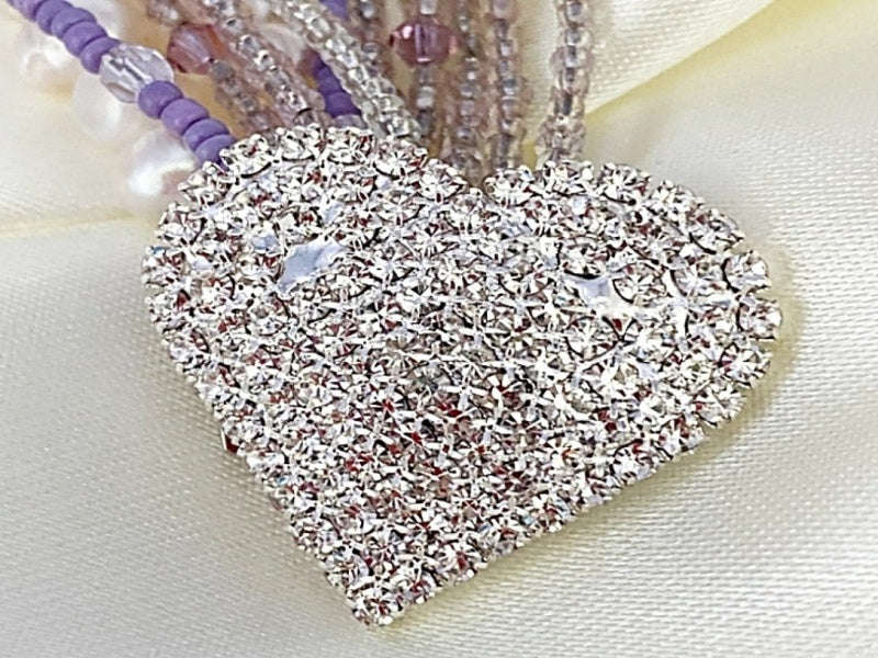 A beautiful Pearl and Lilac Jade Lariat Necklace featuring freshwater pearls, lilac jade, and a faux rhinestone heart button, elegantly displayed.