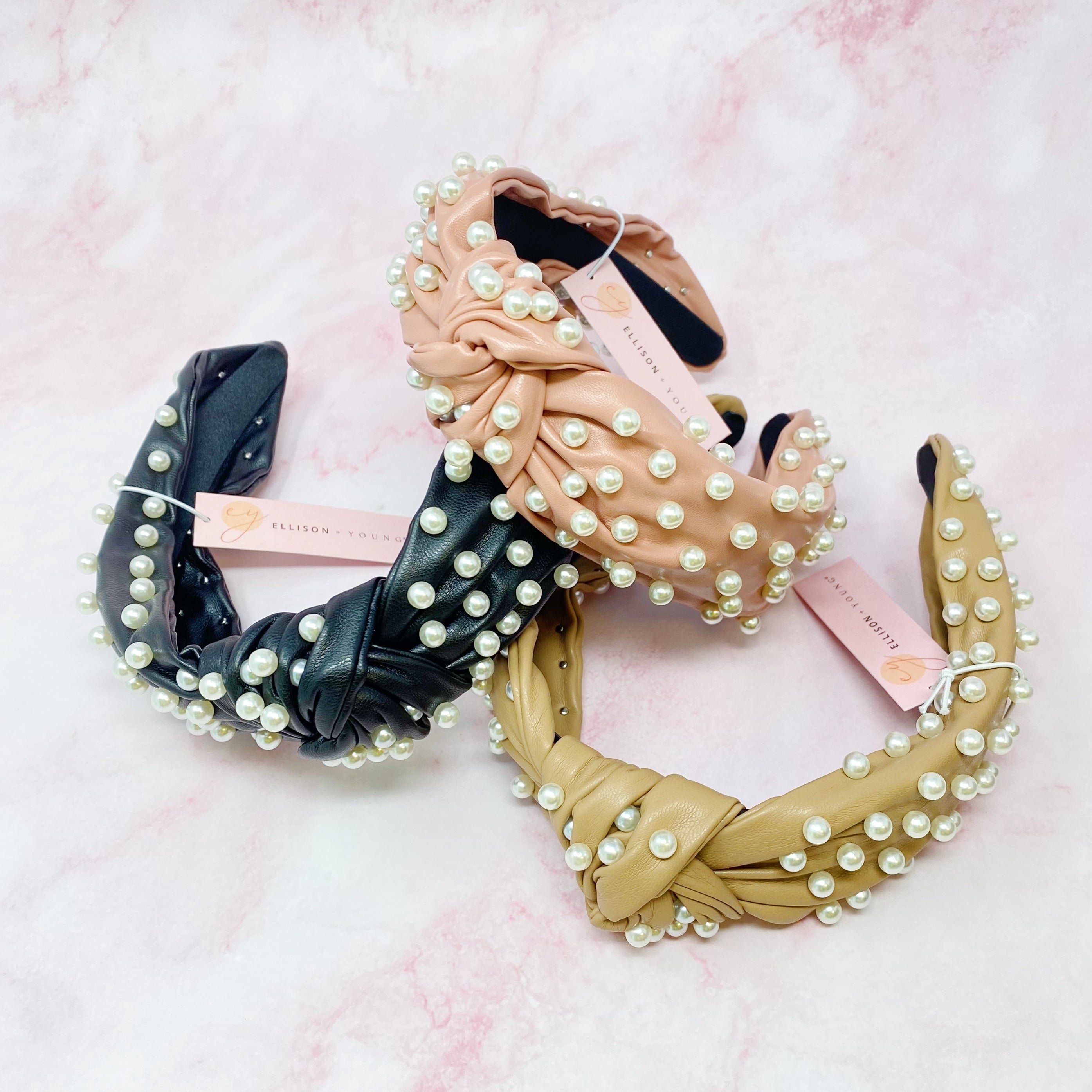 A stylish Pearled Up Vegan Leather Headband featuring soft vegan leather and elegant pearl embellishments in neutral colors.