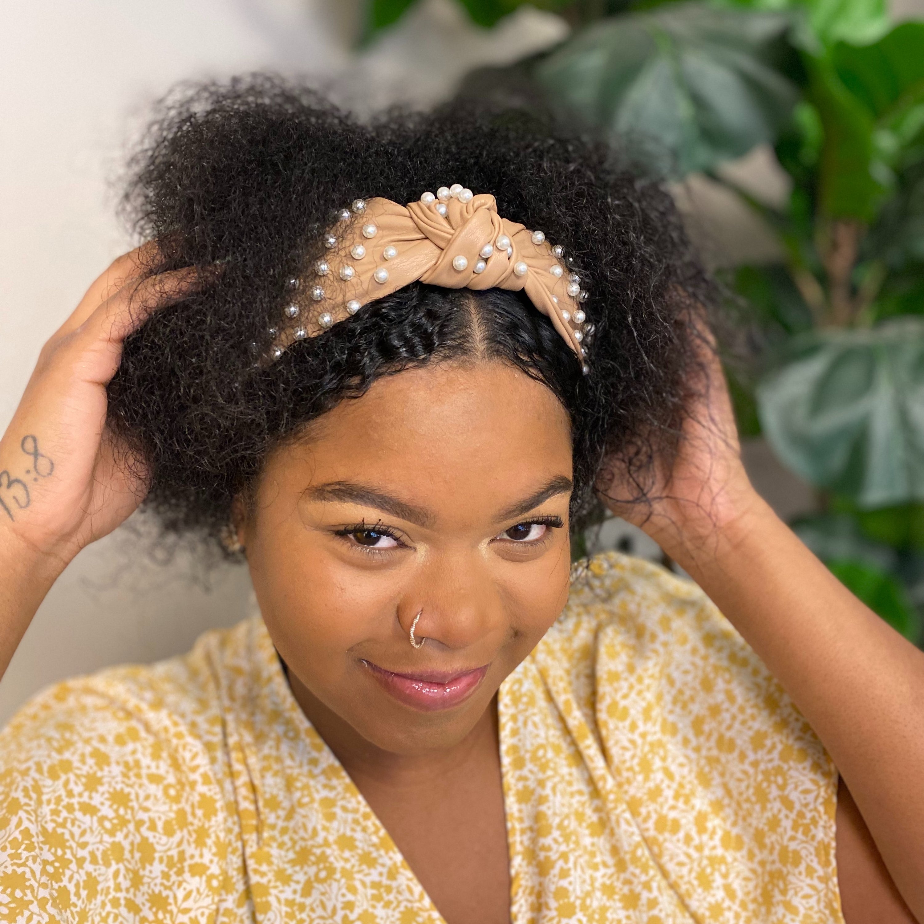 A stylish Pearled Up Vegan Leather Headband featuring soft vegan leather and elegant pearl embellishments in neutral colors.
