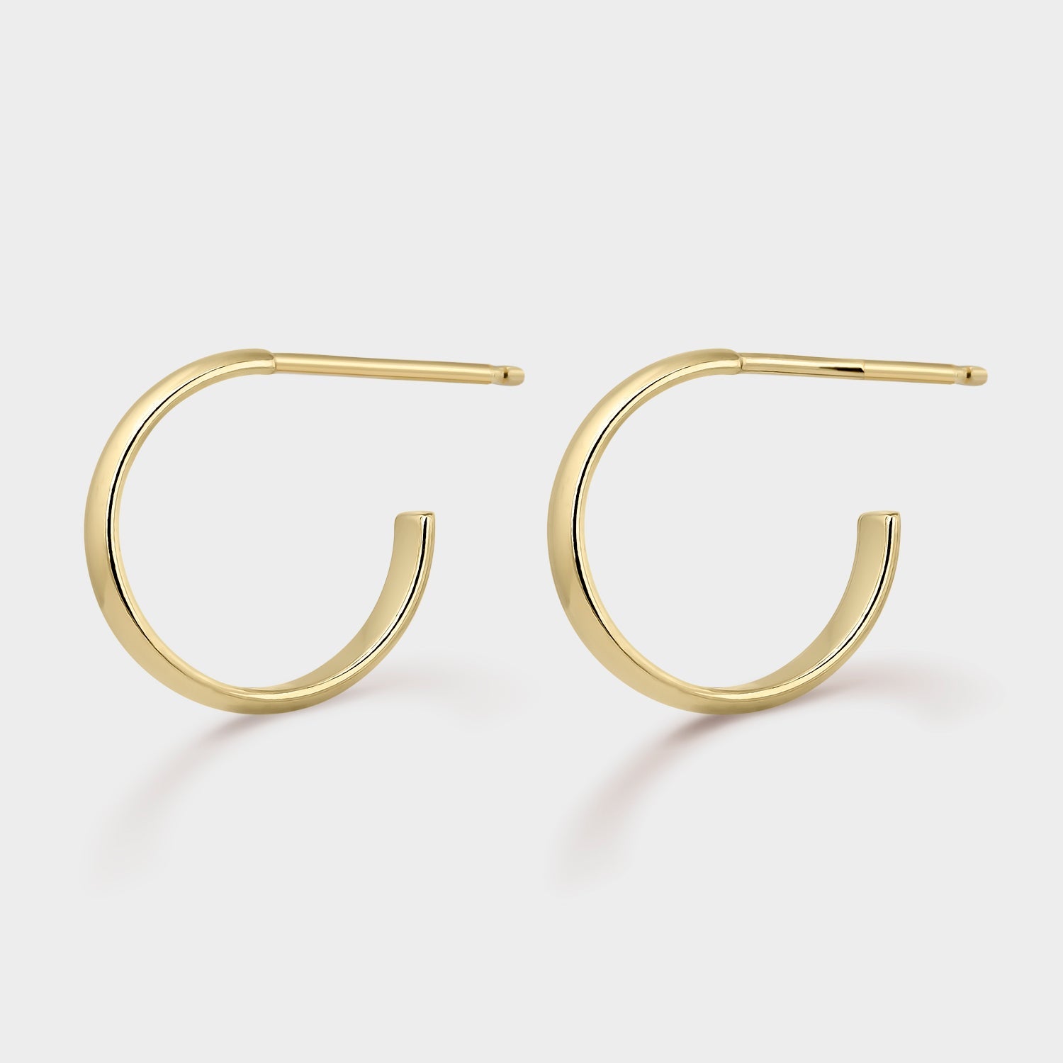 Pendientes aro chapados en oro de 24kt, disponibles en tamaños de 10mm y 15mm, con un diseño elegante y cierre de presión.