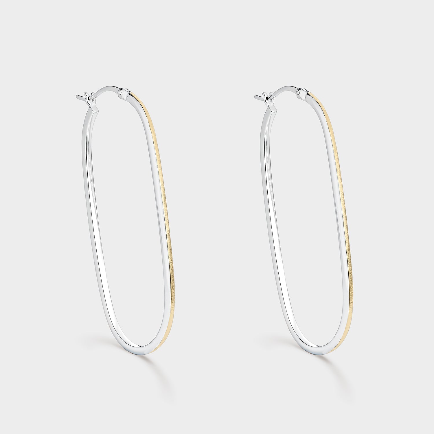 Pendientes aros ovales y alargados bicolor en plata de ley 925 con baño de oro de 18K, mostrando su textura mate y elegante interior plateado.