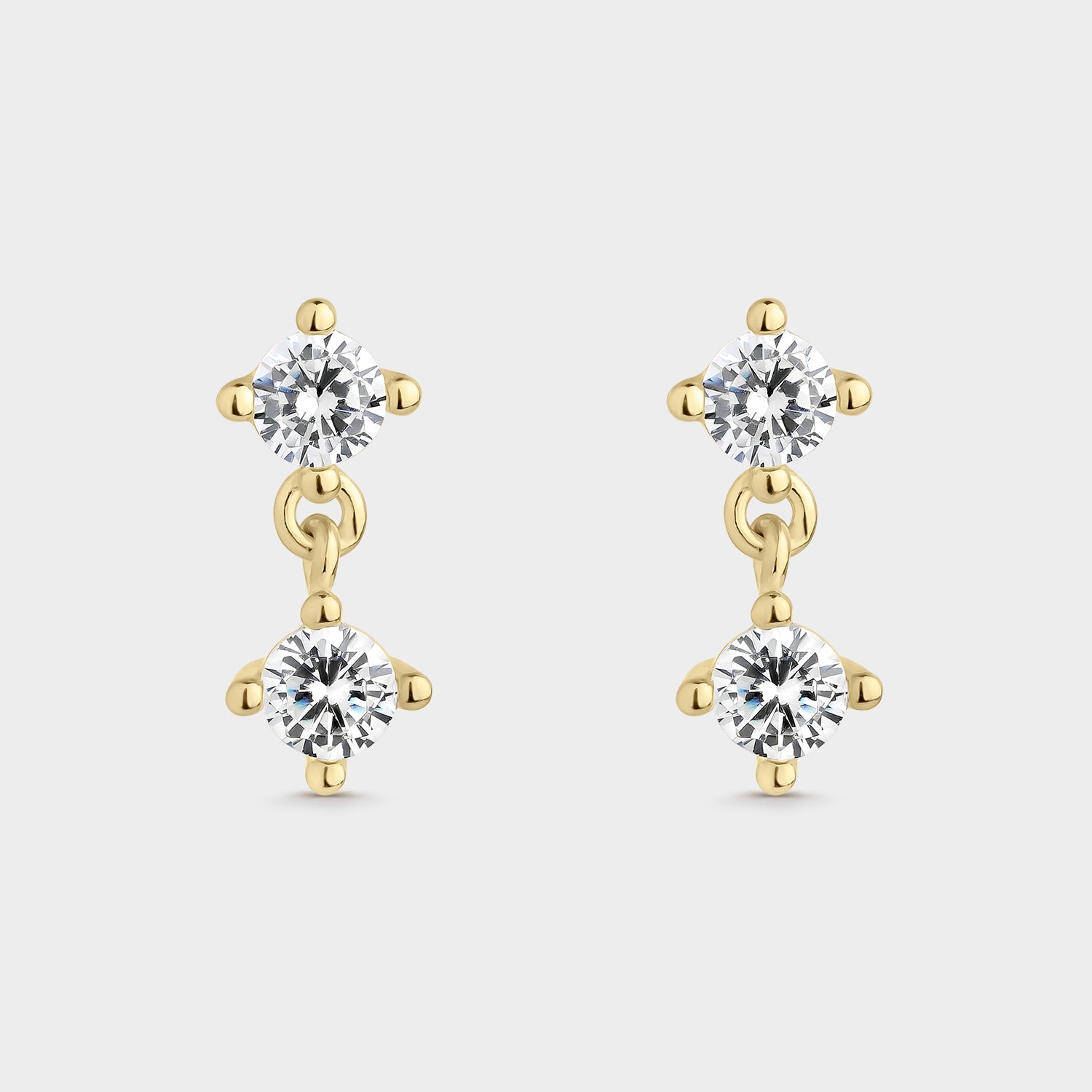 Pendientes elegantes bañados en oro amarillo con circonitas blancas brillantes, perfectos para cualquier ocasión.