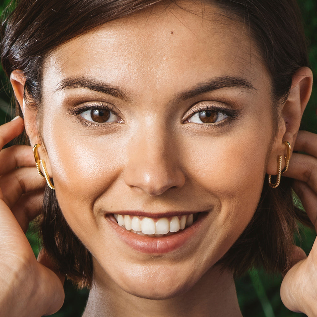 Pendientes elegantes en forma de U, bañados en oro 18k con circonitas brillantes, presentados en una caja de regalo.