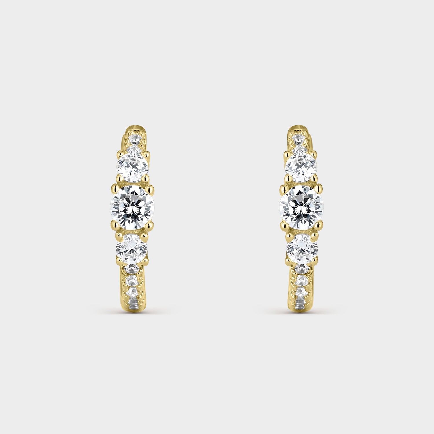 Pendientes criollas de plata bañada en oro amarillo con circonitas blancas, mostrando su brillo y elegancia.