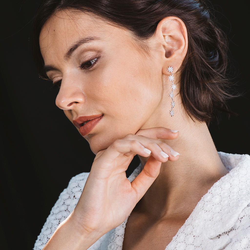 Pendientes largos de flores en plata con circonitas blancas, elegantes y brillantes, perfectos para cualquier ocasión.