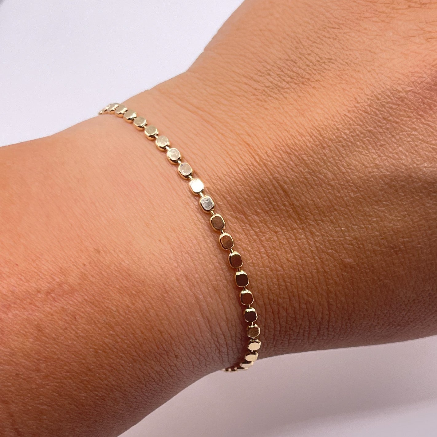 Penelope 18K Gold Filled Bracelet/Anklet featuring a dainty flat ball disc design, shining elegantly in light.