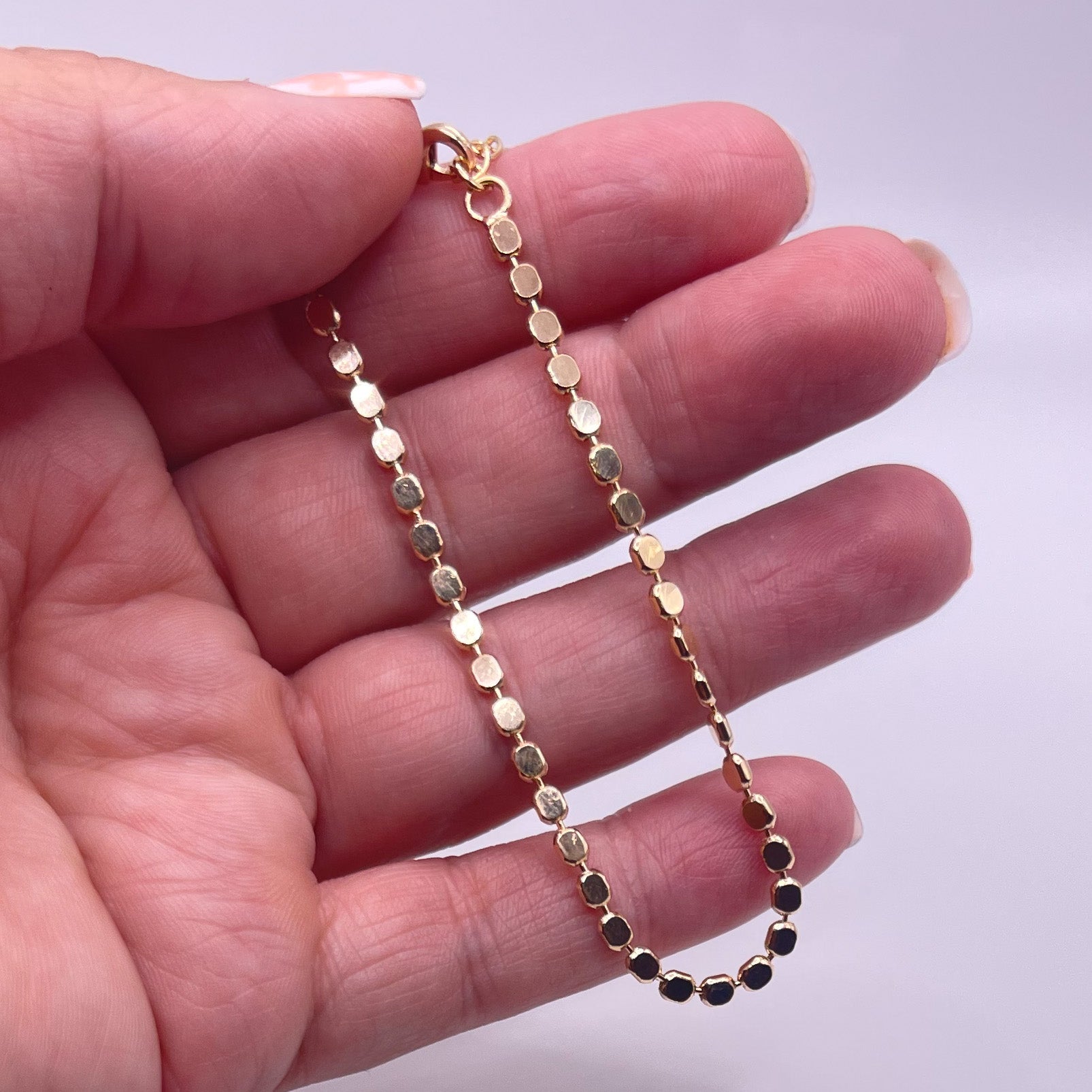 Penelope 18K Gold Filled Bracelet/Anklet featuring a dainty flat ball disc design, shining elegantly in light.