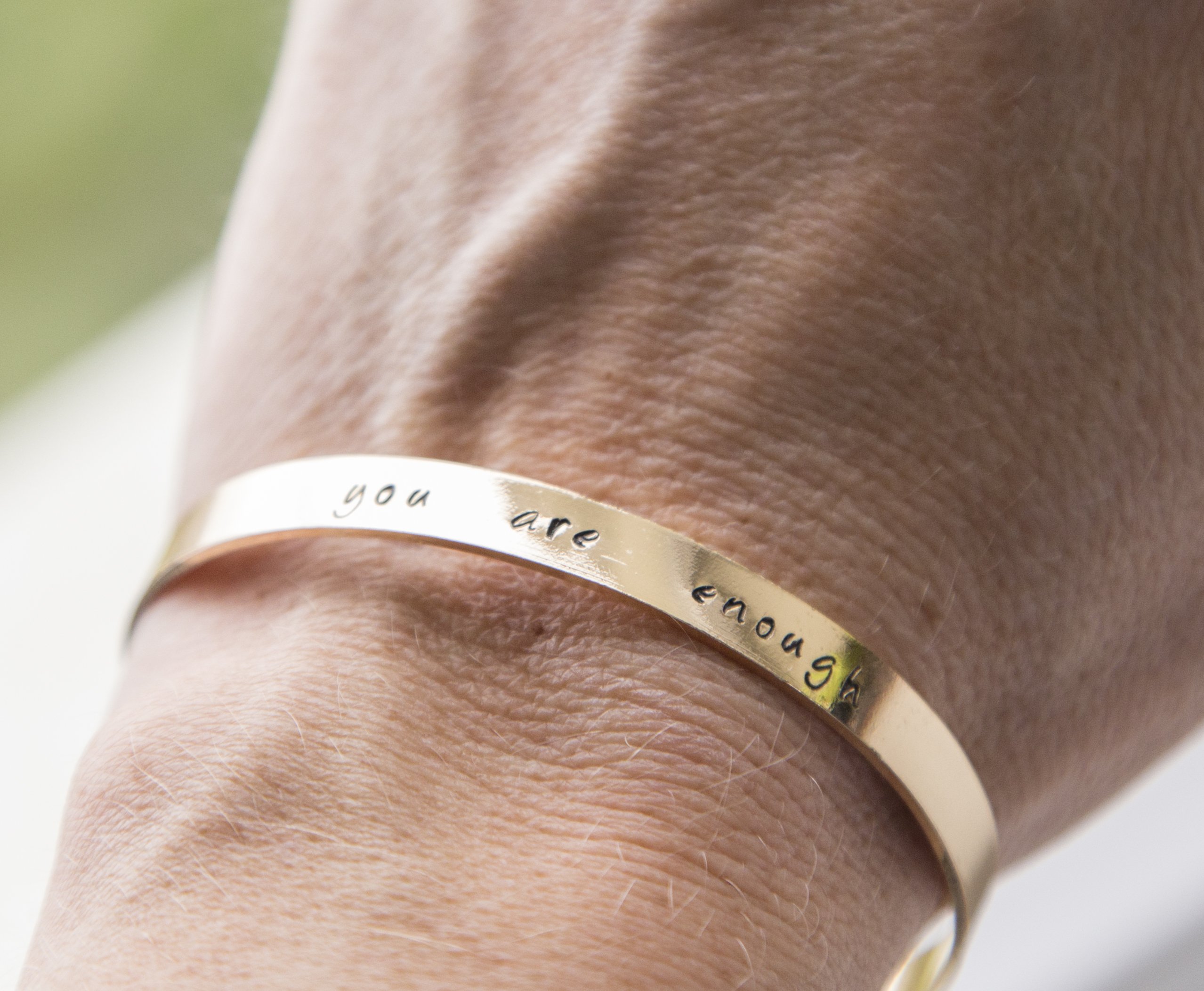 Personalized stamped cuff bracelet in copper with rose gold plating, featuring a custom hand-stamped message.