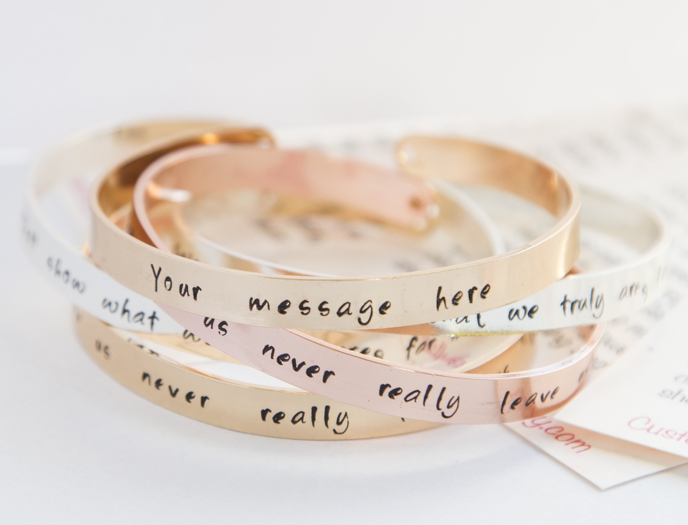 Personalized stamped cuff bracelet in copper with rose gold plating, featuring a custom hand-stamped message.