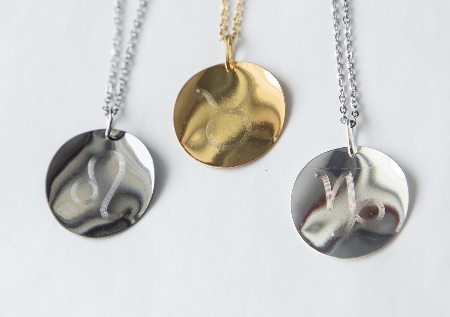 Personalized Zodiac Symbol Pendant in gold plating, featuring a twisted design and attached to a stainless steel necklace.