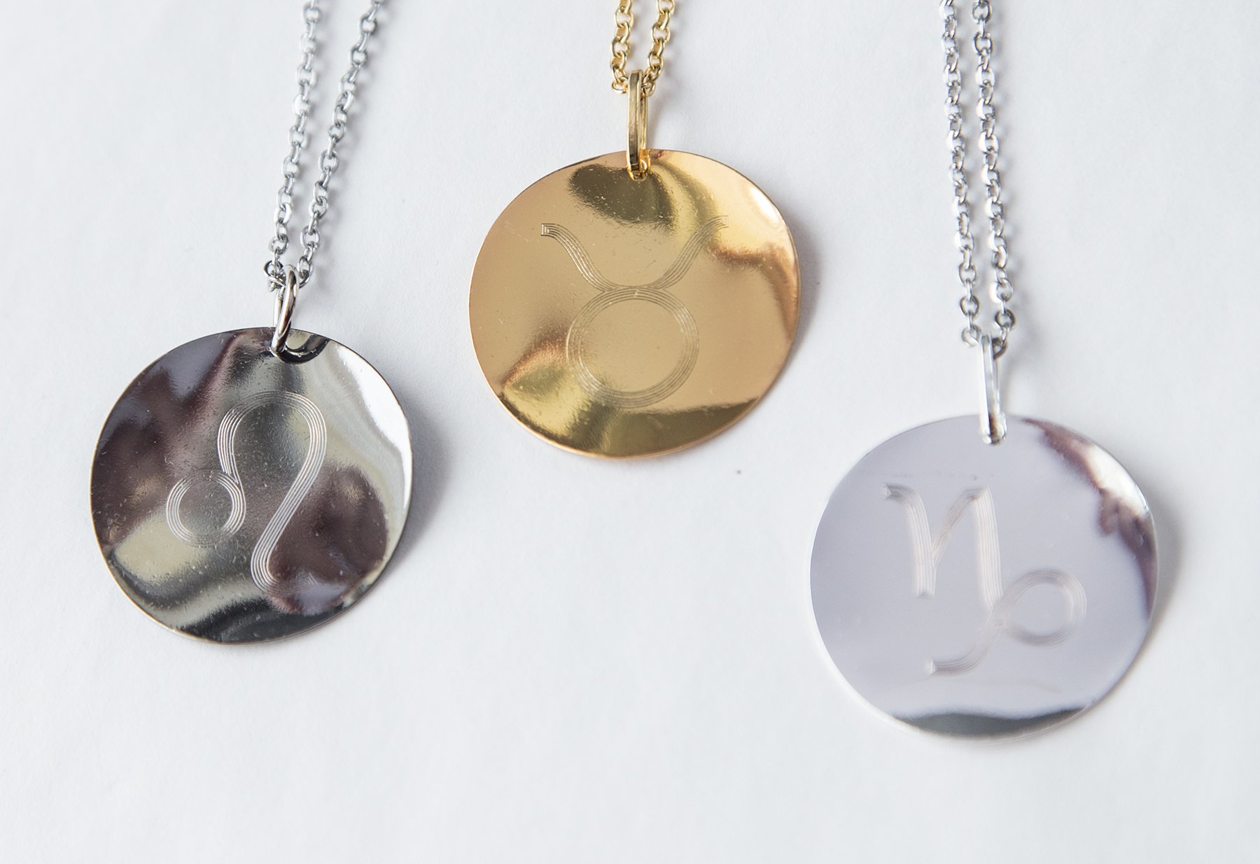 Personalized Zodiac Symbol Pendant in gold plating, featuring a twisted design and attached to a stainless steel necklace.