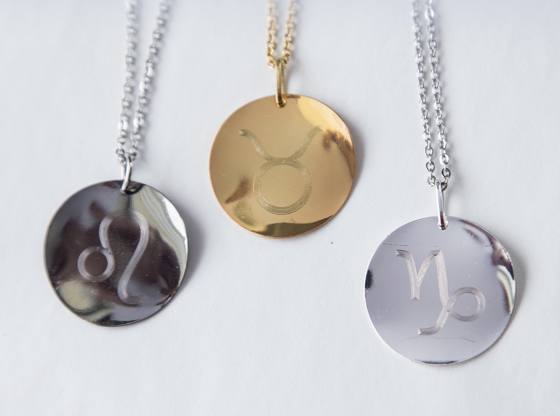 Personalized Zodiac Symbol Pendant in gold plating, featuring a twisted design and attached to a stainless steel necklace.