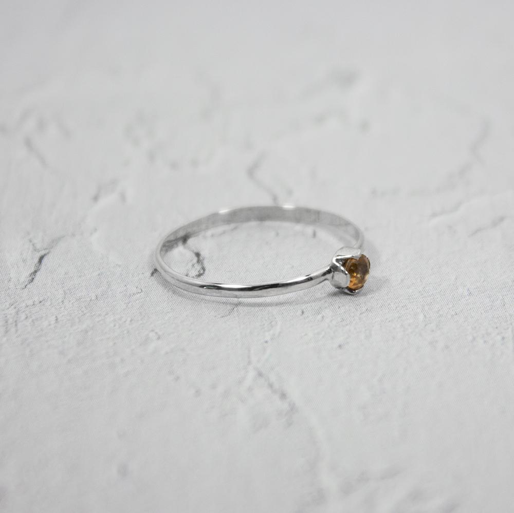 A delicate Petite Citrine Solitaire Ring featuring a round citrine gemstone set in a unique castle setting, crafted from 925 sterling silver.