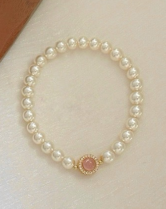 A beautiful Pink Chalcedony and Pearl Bracelet featuring 6mm pearls and pink chalcedony beads, showcasing its elegant design and light-responsive properties.