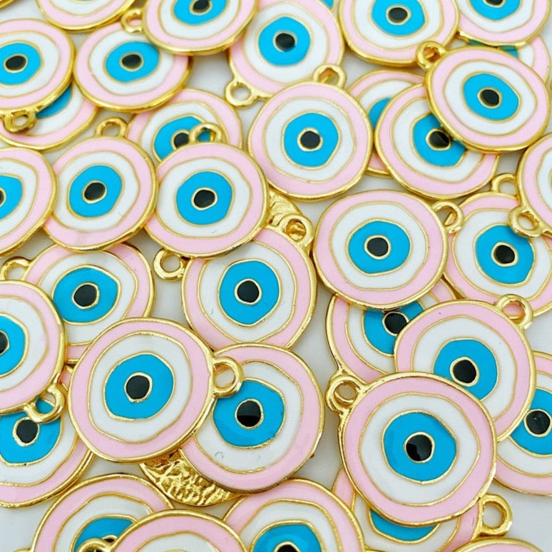 A beautiful pink evil eye charm with gold plating, featuring a traditional evil eye design, perfect for jewelry making.