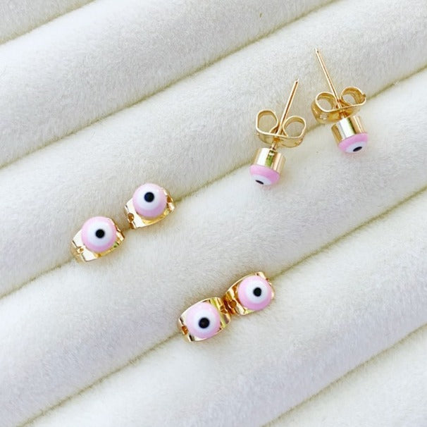 A pair of handmade pink evil eye stud earrings with gold finishing, symbolizing protection and elegance.